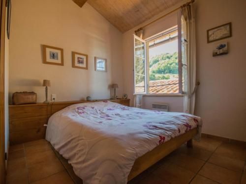 Un dormitorio con una cama grande y una ventana. en Gite des Kathares, en Villeneuve dʼOlmes