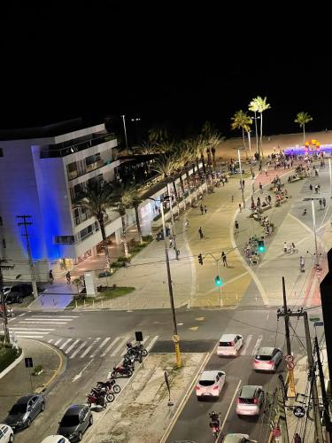 a busy city street at night with cars parked at Buenos Ayres Flats, Cabo Branco 1qto cozinha completa in João Pessoa