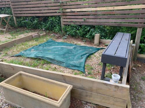 a garden with a table and a blanket and a bench at Flying Fox Backpackers in Katoomba