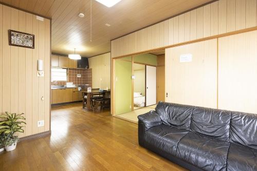 福岡市にあるGuest House Shine Brightのリビングルーム(革張りのソファ付)、キッチン