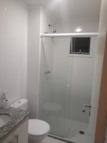 a bathroom with a shower with a toilet and a sink at Apartamento 500m Praia da Enseada Guarujá varanda e vaga de garagem in Guarujá