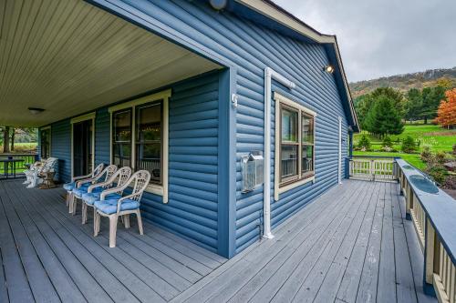 a blue house with chairs on a deck at Gleanings Pond in McHenry