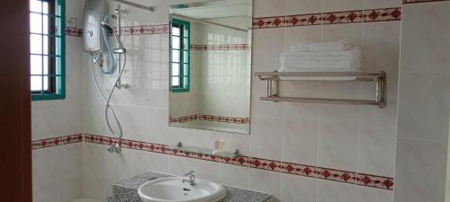 uma casa de banho com um lavatório, um chuveiro e um espelho. em D Savoy @ A'Famosa by RK em Malaca