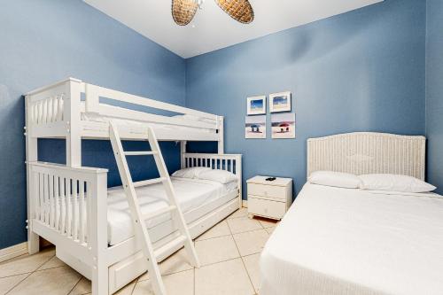 a bedroom with two bunk beds and blue walls at Saturn Serenity & Condo in South Padre Island