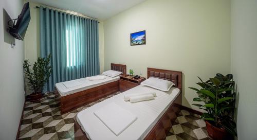 a room with two beds and a tv in it at OQ UY Hotel in Tashkent