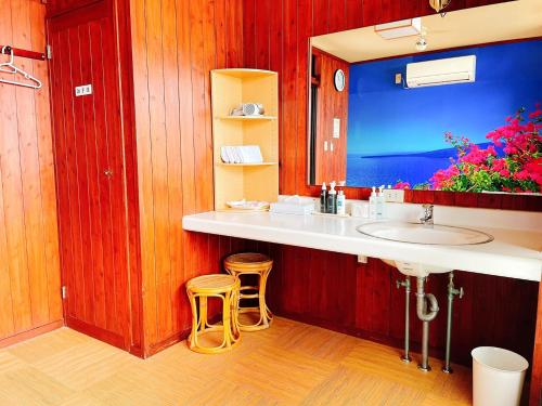 a bathroom with a sink and two stools at Tenku Yubo Seikaiso in Beppu