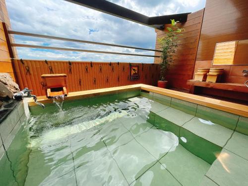 a pool of water with a chair in a house at Tenku Yubo Seikaiso in Beppu
