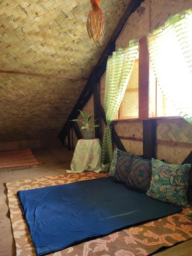 a bed in the attic of a room at Purple Homestay Hillside in Coron