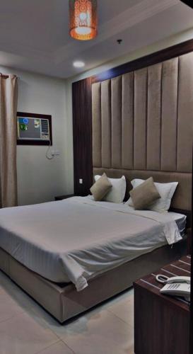 a bedroom with a large bed in a room at الشاطئ الأبيض للشقق المخدومة in Rayyis