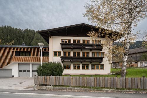 a white house with a black roof at Gästehaus Fohringer in Kelchsau
