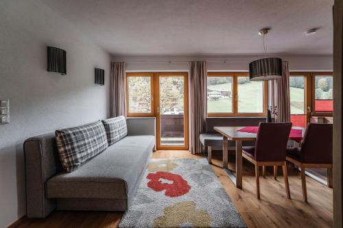 ein Wohnzimmer mit einem Sofa und einem Tisch in der Unterkunft Gästehaus Fohringer in Kelchsau