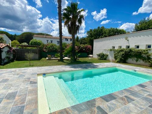 a swimming pool in the yard of a house at Le Mas du Bijou Bleu in Puget-sur-Argens