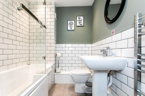 a bathroom with a sink and a toilet and a tub at Portland Apartments 198 by #ShortStaysAway in Newcastle upon Tyne