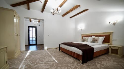 - une chambre avec un grand lit dans l'établissement Curtea Veche, à Hunedoara