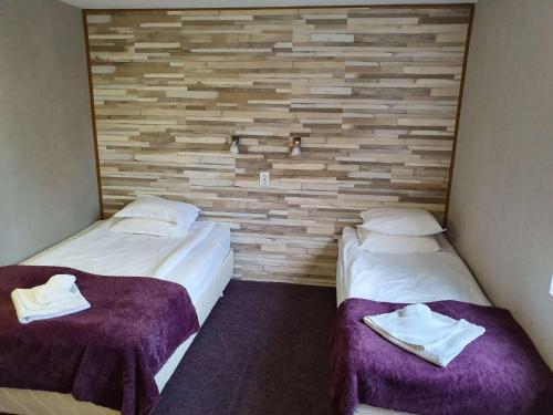 two beds in a room with a brick wall at Sea Horse in Burgas City