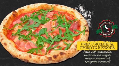 a pizza with ham and greens on a table at Sea Horse in Burgas City