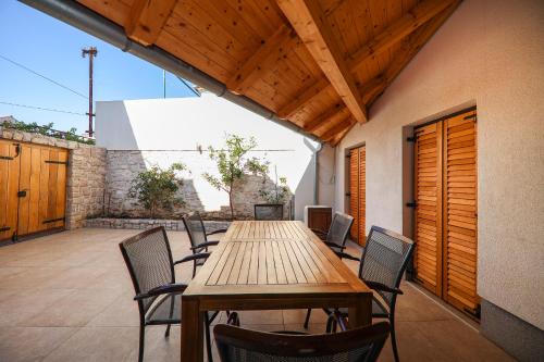 a wooden table and chairs on a patio at Janino Murter in Murter