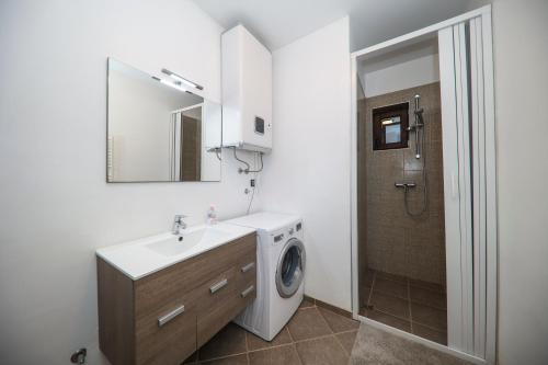 a bathroom with a sink and a washing machine at Janino Murter in Murter