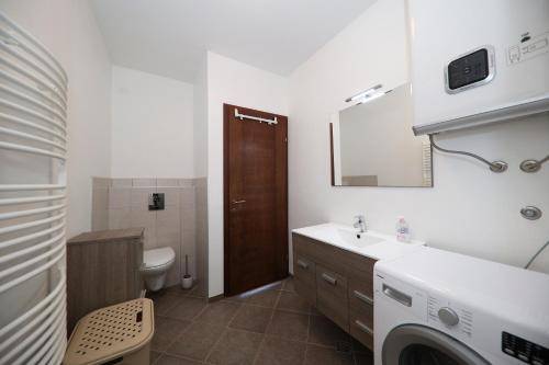 a bathroom with a sink and a washing machine in it at Janino Murter in Murter