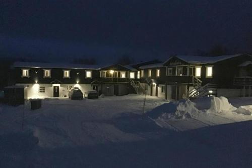 a house with lights in the snow at night at Åreskutans lägenhet i Huså - med laddning för bil 22 kw in Huså