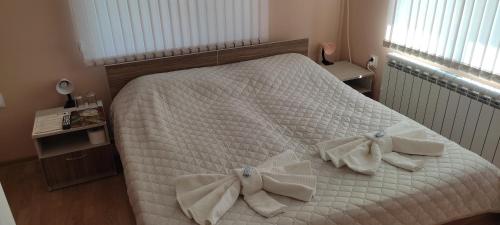 sypialnia z białym łóżkiem i ręcznikami w obiekcie Къща за гости СВЕТЛАНА w mieście Saparewa Banja
