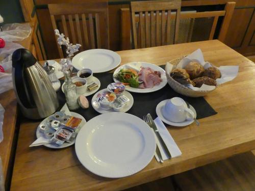 罗滕堡拜耶里切霍夫酒店的木桌,上面放有盘子和碗的食物