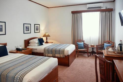 仰光的住宿－贏家旅館，酒店客房设有两张床和窗户。