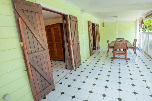 a room with a table and a wooden door at Baobab et Palmiers in Étang-Salé