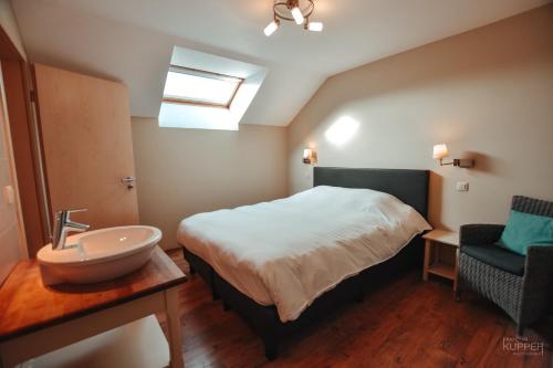 a bedroom with a bed and a sink in it at Le vieux Sanglier - 41 pers - Malmedy in Malmedy