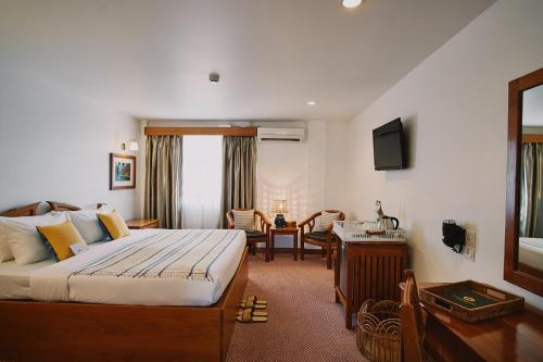 a hotel room with a bed and a living room at Winner Inn in Yangon