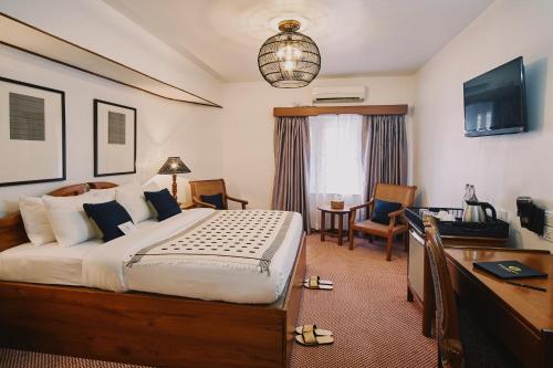a hotel room with a large bed and a desk and a desk at Winner Inn in Yangon