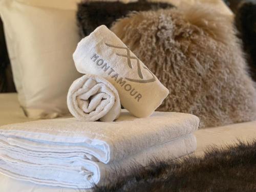 a pile of towels on a bed with a towel at Chalet Azalée, Montriond, Morzine, Avoriaz in Montriond