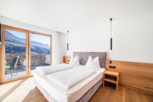 um quarto com uma cama grande e uma janela grande em Oberegghof Ferienwohnung Garten em Rifiano