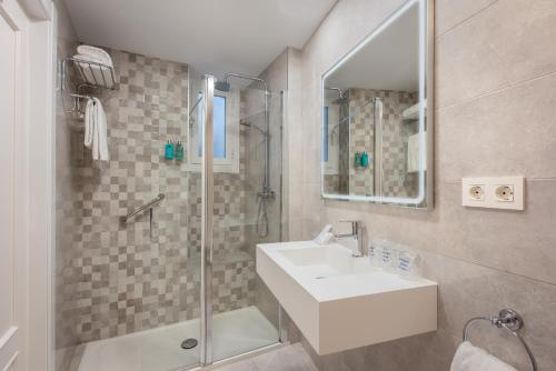 a bathroom with a sink, mirror, and bathtub at Anacapri in Granada