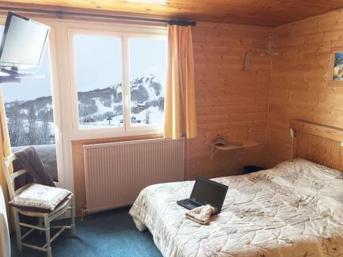 a bedroom with a bed with a laptop on it at Le Sestriere in La Foux