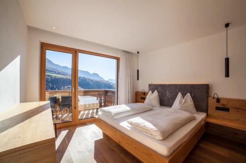 1 dormitorio con cama y ventana grande en Oberegghof Ferienwohnung Ifinger, en Rifiano
