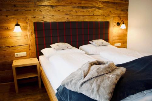 two beds in a room with wooden walls at Birg 1414 in Warth am Arlberg
