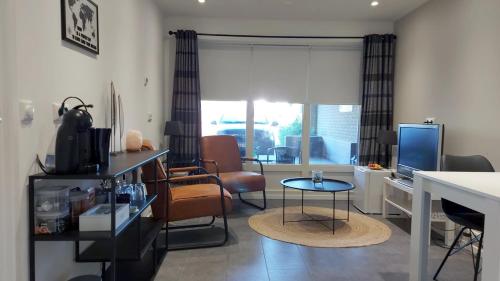 een woonkamer met een tafel en stoelen en een televisie bij B&B Margriet in Lemmer