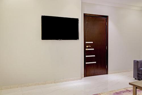 a television on a wall next to a door at Al Tamayoz Al Raqi - Bani Malik in Jeddah