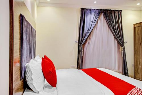 a bedroom with a bed with red and white pillows at Al Tamayoz Al Raqi - Bani Malik in Jeddah