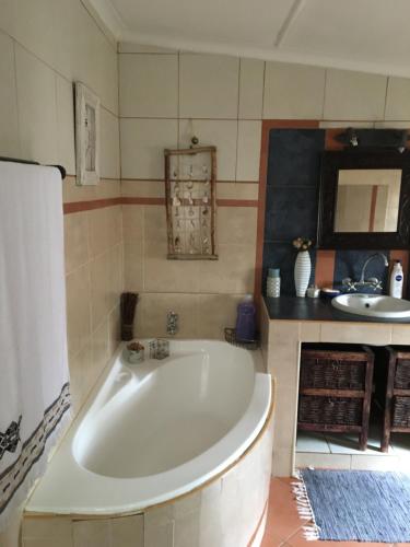 a large white tub in a bathroom with a sink at Bloekomhuis in Smithfield