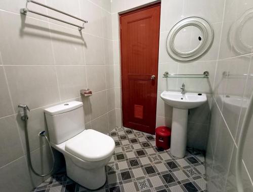 a bathroom with a toilet and a sink with a mirror at Comfort Hotel in Kota Kinabalu