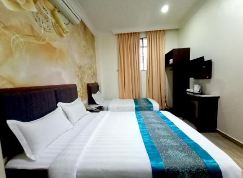 a hotel room with a large white bed in it at Comfort Hotel in Kota Kinabalu