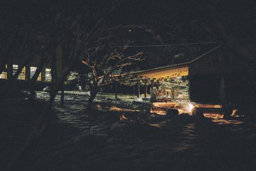 a building at night with a person sitting outside at Blickinsfreie - Cabin in Schöneck