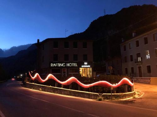a building with a sign that reads parking hotel at night at Rafting Hotel Ai Cavallini in Solagna