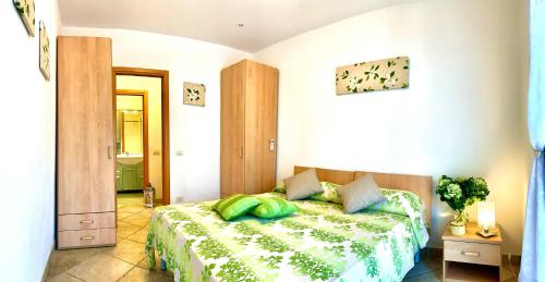 a bedroom with a bed with green pillows on it at Casa in Maremma Tuscany Village in Scarlino