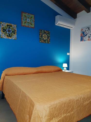 una camera blu con un letto con due immagini sul muro di Casa vacanza L'antico moderno a Terrasini