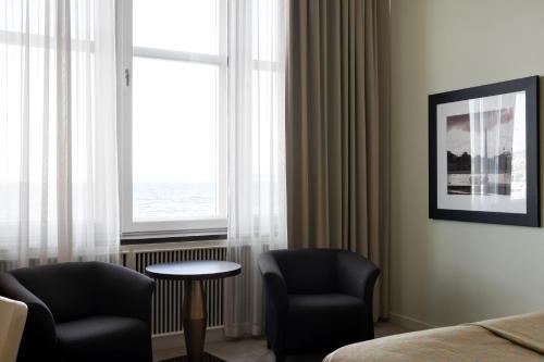 a room with two chairs and a table and a window at Elite Stora Hotellet in Jönköping