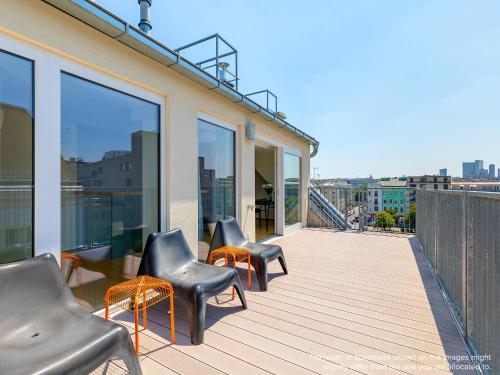 - un balcon avec des chaises et des tables dans un bâtiment dans l'établissement numa I Strauss Apartments, à Vienne