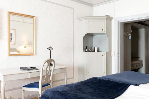 a bedroom with a bed and a desk and a mirror at Elite Stora Hotellet in Jönköping